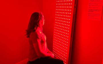 woman sittingin fron tof red light therapy infrared red ilght in provo at holistic wellness center stronglife physiotherapy in utah county with immune boosting red light heals skin conditions, boosts mood, improves melatonin better sleep and less wrinkles free with hyperbaric oxygen therapy at hyperbaric clinic