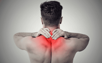 Man holding upper back in pain due to muscle tension causing tension headaches, neck stiffness, and radiating pain—relieved by Stronglife Physiotherapy's dry needling, shockwave therapy, and posture correction treatments for chronic upper back pain and headaches.